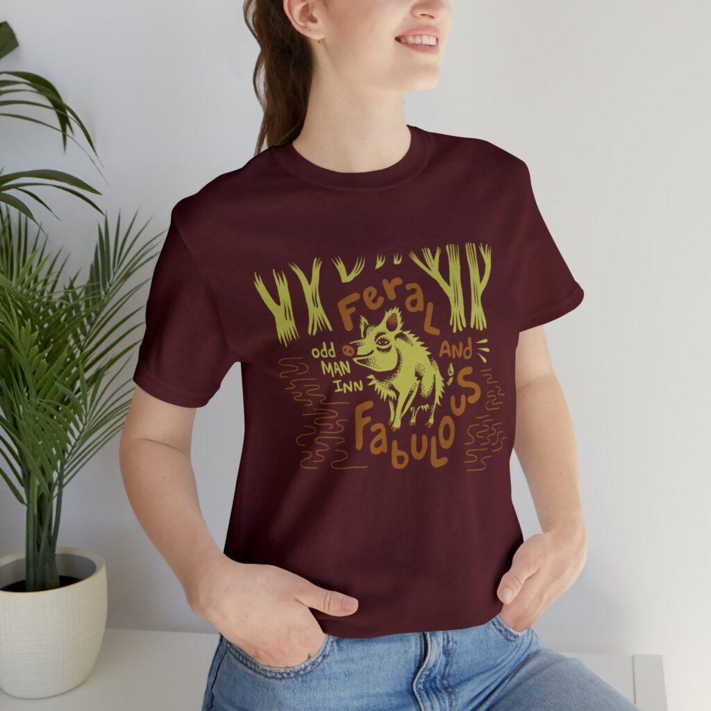 Model wearing an Odd Man Inn Feral and Fabulous shirt with an illustrated pig.
